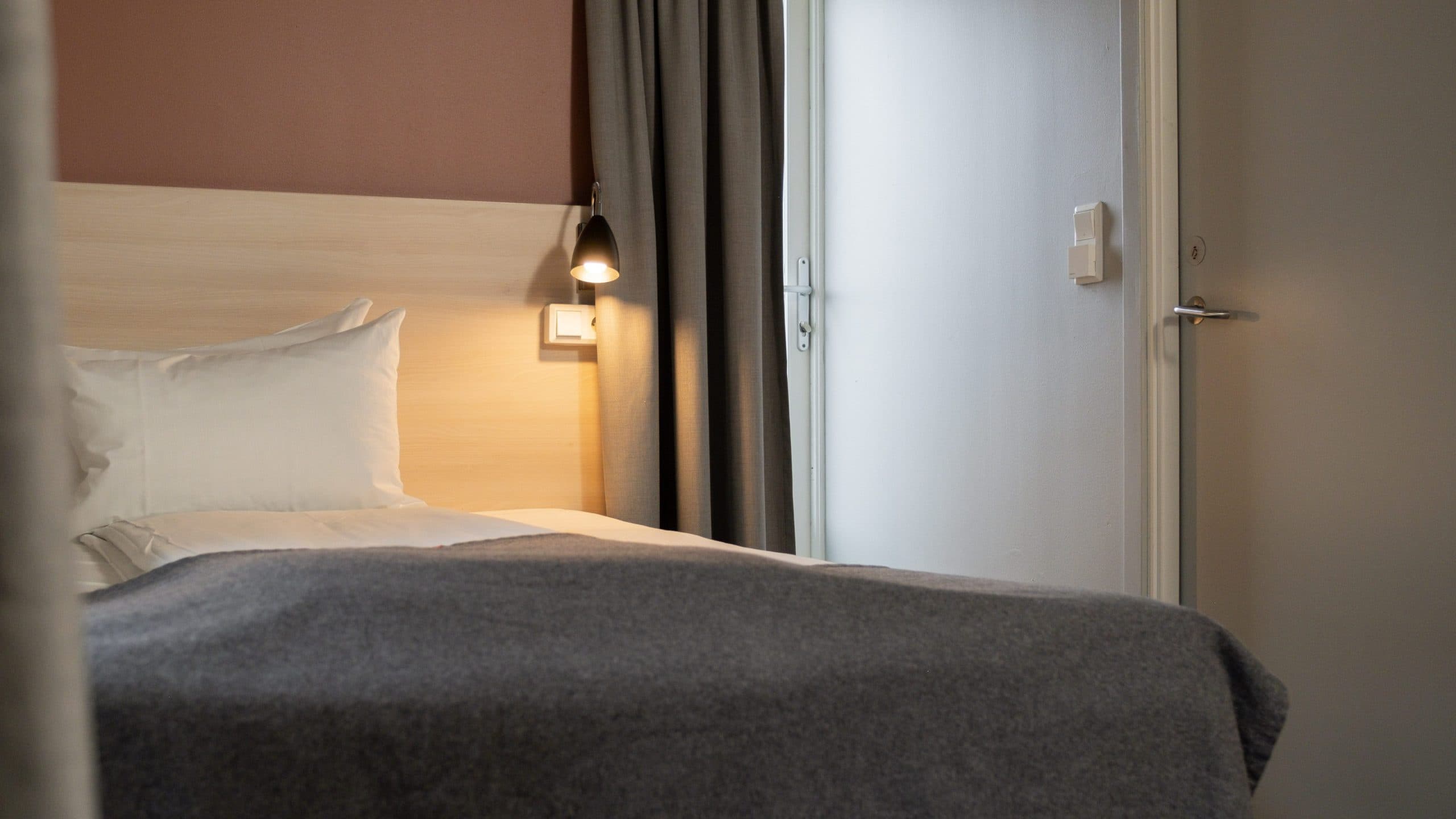 Picture of single room at Citybox Oslo. You can see the balcony door in the back