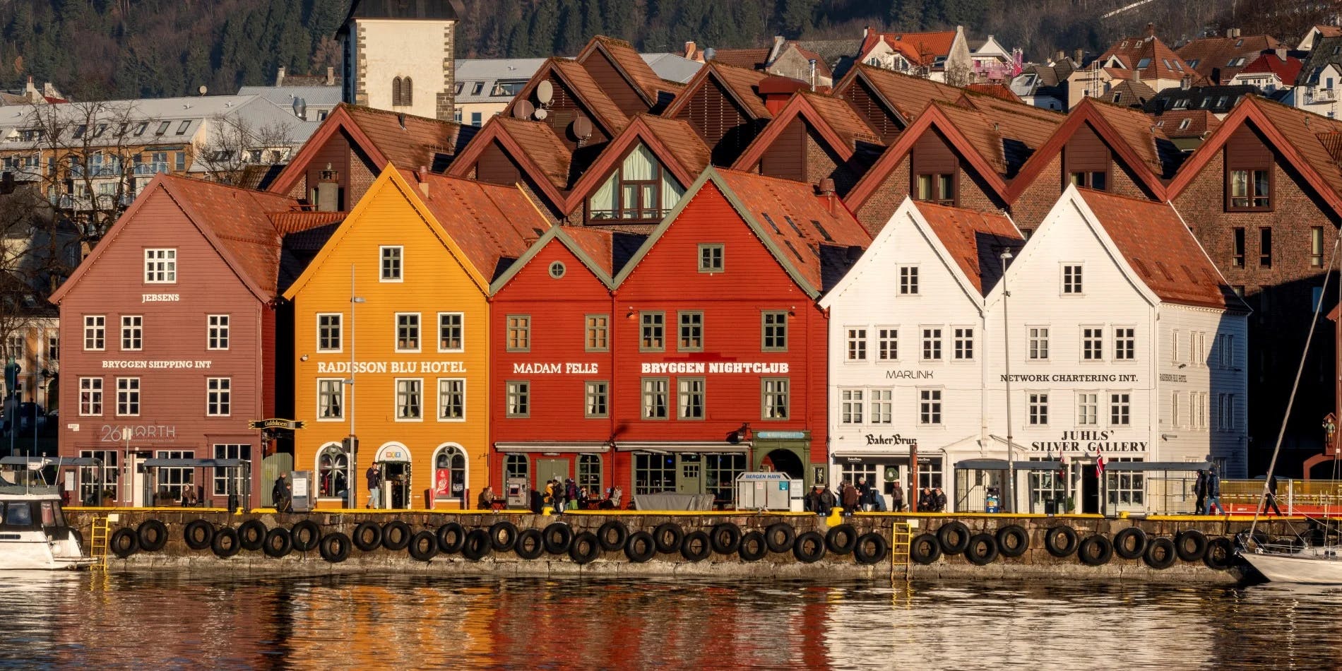 Image of Bryggen Hanseatic Wharf. Old buildnings next to the water.