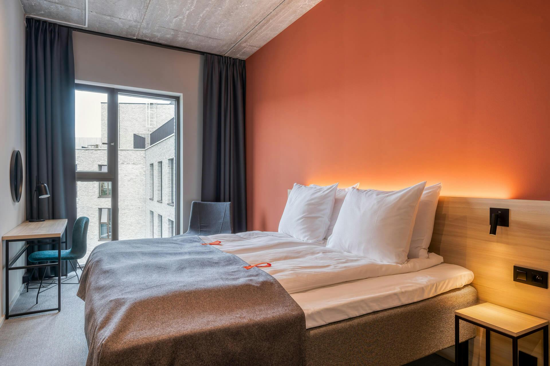 Double bed, big window, orange wall, desk, chair